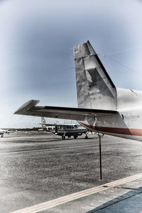 Airplane on airport runway against sky