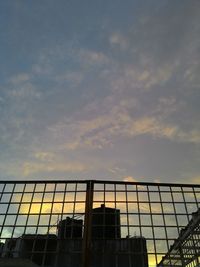 Low angle view of modern building against cloudy sky