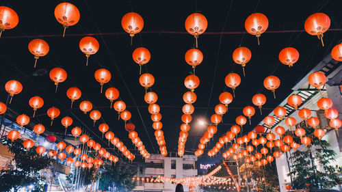 Low angle view of illuminated lanterns hanging at night