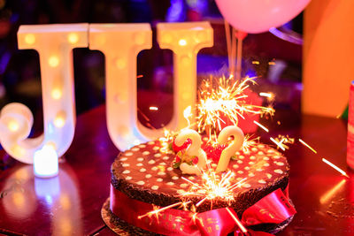 Illuminated candles on birthday cake