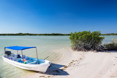 Scenic view of beach against clear blue sky