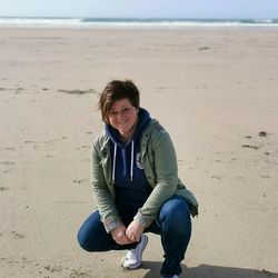 Portrait of smiling young woman sitting on beach