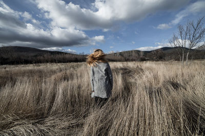 Woman standing on field against sky