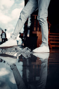 The young man swings his foot on the water. reflection