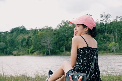 Side view of young woman looking at camera