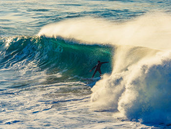 Person surfing on waves at sea