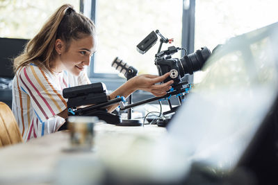 Smiling businesswoman using camera in office