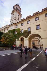 Group of people walking on road amidst buildings in city