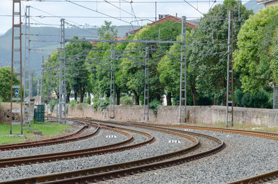 Railroad tracks by trees against sky