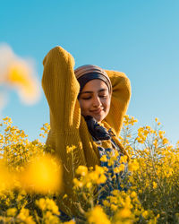 Young woman wearing hat on field against sky