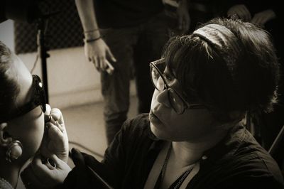 Close-up of woman applying lipstick of daughter lips