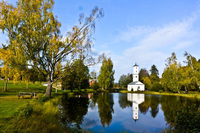 Church by lake against sky
