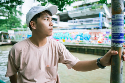 Young man looking away by pole