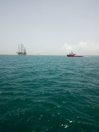 Boat sailing in sea against clear sky