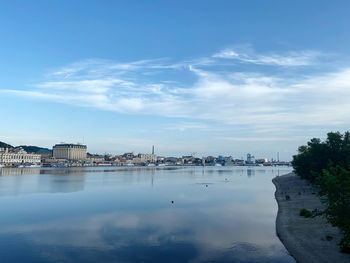 Scenic view of lake by buildings against sky