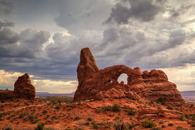 Rock formations on landscape against cloudy sky