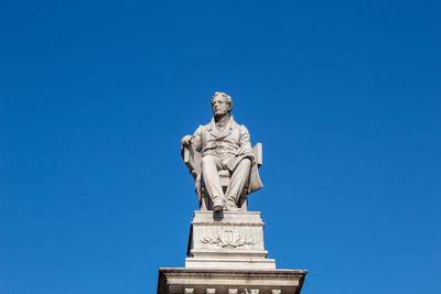 Low angle view of statue against blue sky