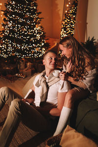 A romantic couple in love celebrates christmas holidays and new year in a cozy house at night