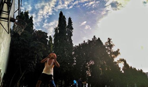 Low angle view of woman standing against sky