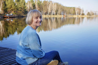 Portrait of woman sitting by lake