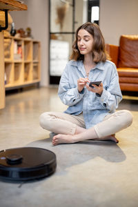 Young woman smiling while sitting on floor