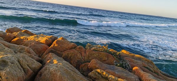 Scenic view of rocks on beach against sky