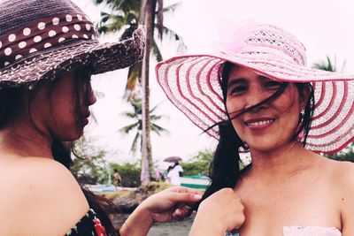 Smiling women wearing hat standing outdoors