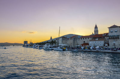 Scenic view of sea and buildings against sky during sunset