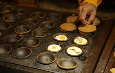 Close up photo of street food person making banh can, vietnamese rice flour pancake