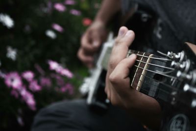 Midsection of man playing guitar