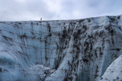 Cropped unrecognizable heaven ice formation of vatnajokull glacier with tourist located against cloudy gray sky on winter day in iceland