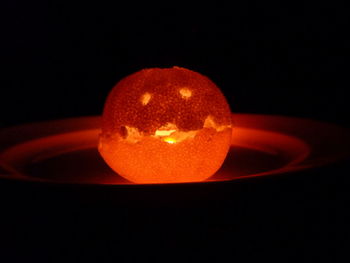 Close-up of illuminated candle against black background