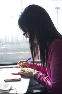 Side view of woman using mobile phone