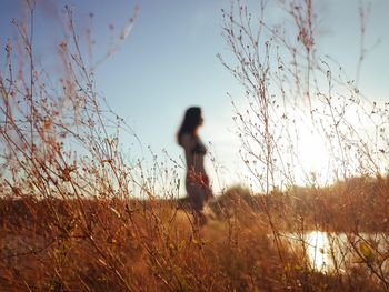 Side view of woman on field against clear sky