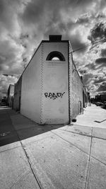 Text on footpath by building against sky