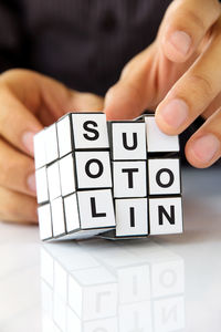 Close-up of hand with puzzle cube on table