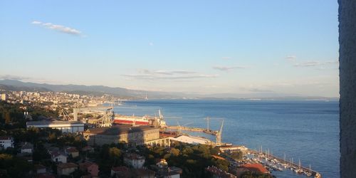 High angle view of city by sea against sky