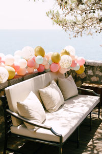 Flower pots on table by sea against sky