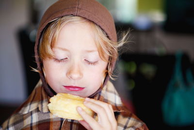 Close-up of boy holding donut at home