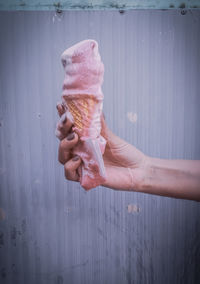 Hand holding melted ice cream cone