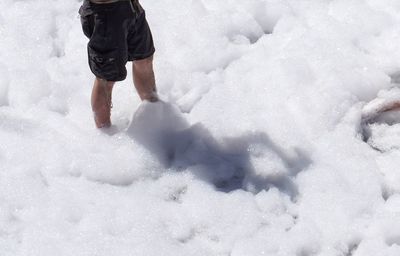 Low section of person walking on foam covered field