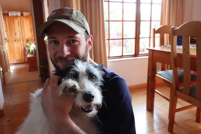 Portrait of man sitting dog at home