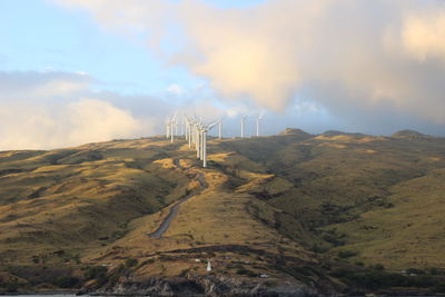 Wind turbines on land against sky