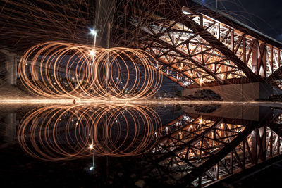 Illuminated ferris wheel against sky at night