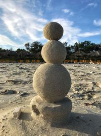 Close-up of sand sculpture on beach against sky