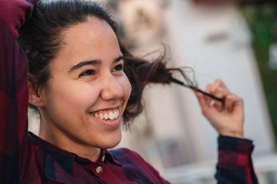 Portrait of a smiling young woman holding camera