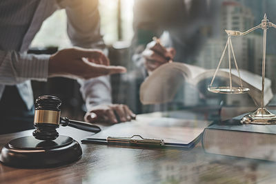 Midsection of lawyers doing paperwork in office