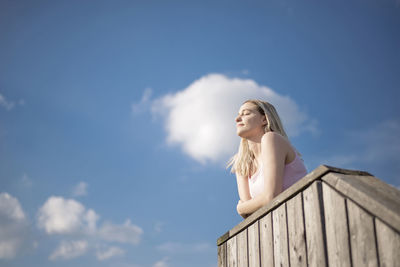 Low angle view of beautiful woman standing against sky