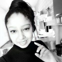 Portrait of smiling young woman holding camera
