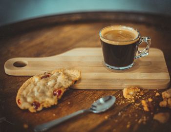 Close-up of coffee cup and cookie on serving board